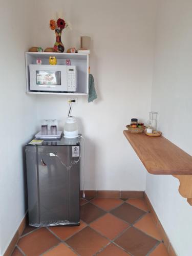 Una cocina con microondas y suelo de baldosas. en Cabaña Deluxe en Villa de Leyva, VillaClarita, en Villa de Leyva