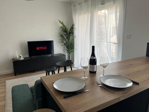 - une table à manger avec une bouteille de vin et des verres dans l'établissement T2 moderne hypercentre - Parking privé, à Agen