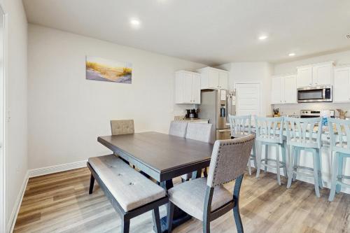 a kitchen and dining room with a wooden table and chairs at Windmark - The Soaring Gull in Highland View