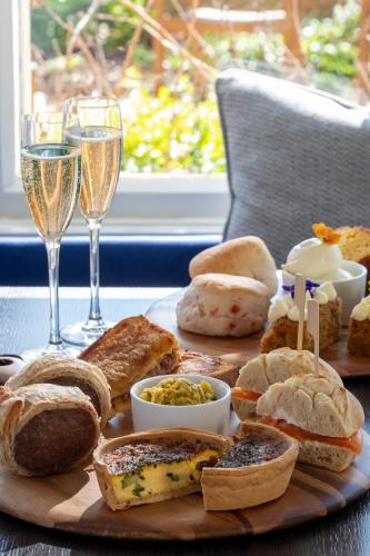 a plate of food with bread and glasses of champagne at Horsted Place Hotel in Uckfield