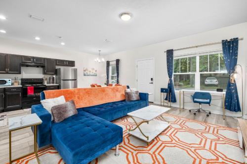 a living room with a blue couch and a kitchen at Beautiful Home, Walk to UF, Newly built in Gainesville