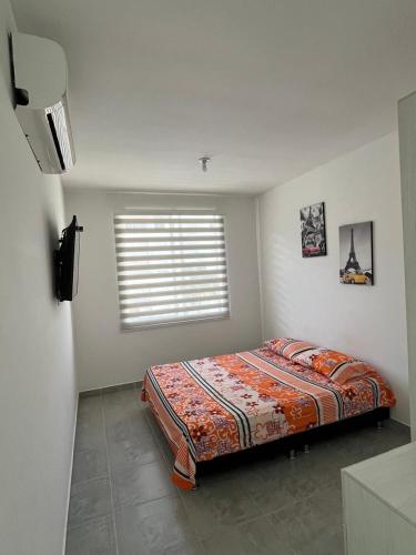 a bedroom with a bed in a room with a window at Apartamento Conjunto Aqualina Orange in Girardot