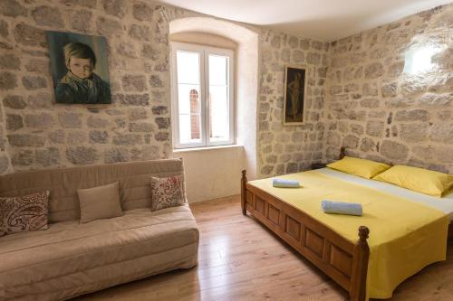 ein Schlafzimmer mit einem Bett und einem Sofa in der Unterkunft Neda Apartment in Kotor