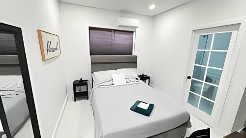 a white room with a bed and a mirror at Private Rooms close to Miami Airport - Free parking - 02 in Miami