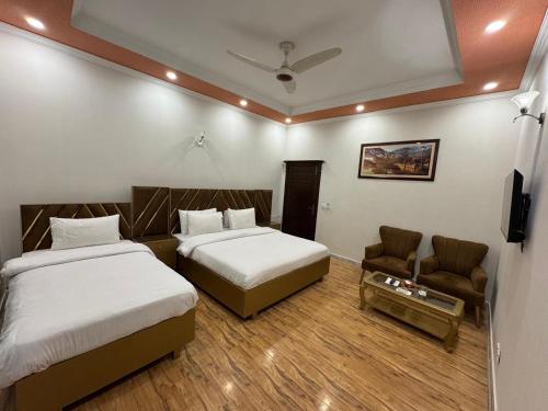 a hotel room with two beds and a couch at Comfort & Luxury Stay In Islamabad in Islamabad