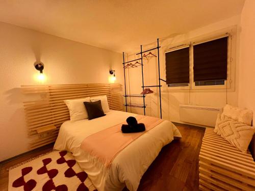 une chambre avec un lit avec un chapeau dessus dans l'établissement Grenoble, Ile Verte, charme, terrasse et calme, à Grenoble