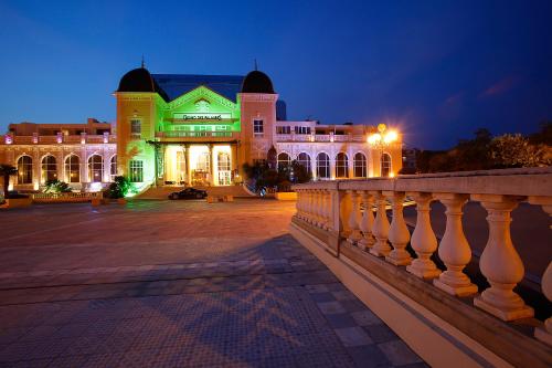 un bâtiment avec un feu vert la nuit dans l'établissement Casino Hôtel des Palmiers, à Hyères