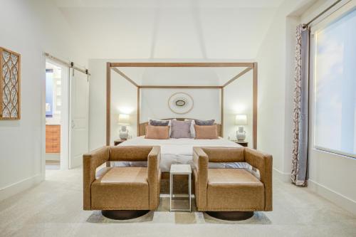 a bedroom with a large bed and two chairs at Maverick's Pool Paradise in San Antonio