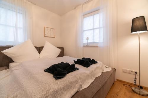a bedroom with a bed with black clothes on it at Haus Christl&Franz in Bad Aussee
