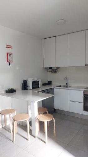 a kitchen with a table and two stools in it at Costa Guest House in Guimarães