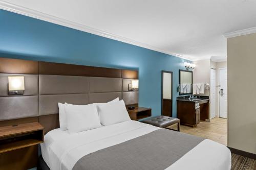 a hotel room with a bed and a bathroom at Best Western Paradise Hotel in Paradise