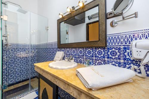 une salle de bain avec un lavabo et un miroir dans l'établissement Riad Luzia, à Marrakech