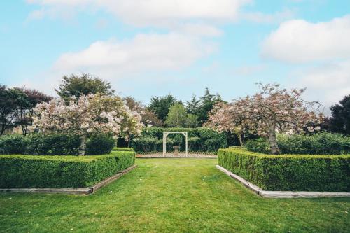 a garden with hedges and a soccer goal at Brackenridge Country Retreat & Spa in Martinborough 