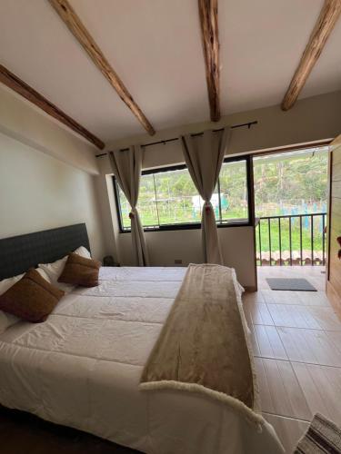 a bedroom with a large white bed with windows at Q'inti Apartment in Lamay