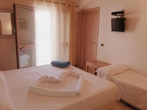 a room with two beds with a heart on it at Hotel Mar & Sol in Punta Secca
