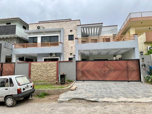 a white car parked in front of a house at Comfort & Luxury Stay In Islamabad in Islamabad
