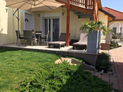 a patio with an umbrella and a table and chairs at Leiner Apartman in Hévíz