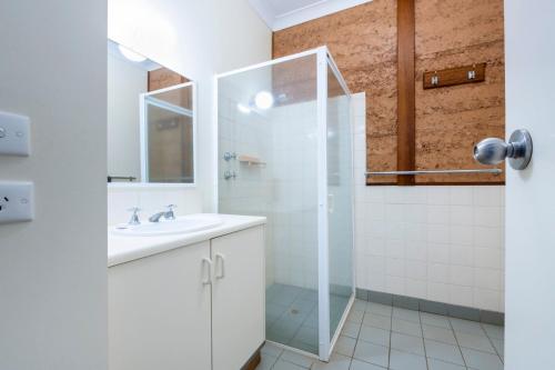 a bathroom with a sink and a shower at Mud Hut Motel in Coober Pedy
