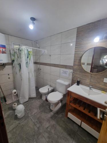 a bathroom with a toilet and a sink and a toilet istg at La esmeralda verde in Villa Ventana