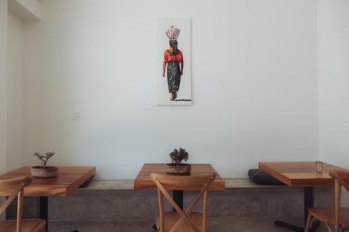 a room with tables and a statue of a person on the wall at Aviva Hotel in Tzununá