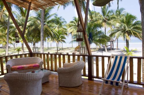 a porch with chairs and a view of the beach at Casa Palmeras Isla Portete in Isla Zapotal