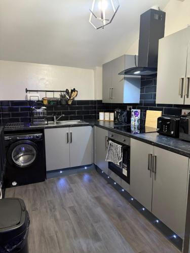 a kitchen with a sink and a dishwasher at Luxury Modern Apartment, Sleeps 4 and Games Room in Bolton