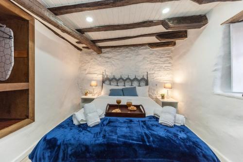 Un dormitorio con una gran cama azul en una habitación. en Charming Seaside Escape in Picturesque Cudillero, en Cudillero