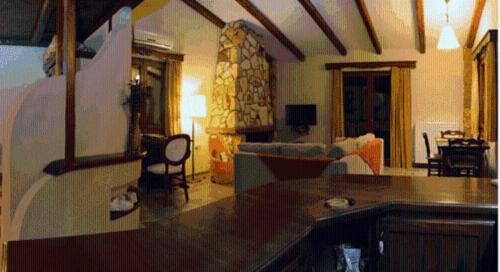 a living room with a kitchen and a living room with a couch at Apolithomeno Dasos Holiday Villas near Alexandroupolis in Lefkimmi