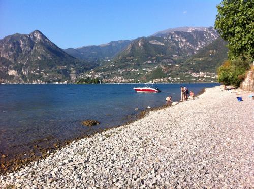 a group of people on a beach with a boat in the water at Hotel Bellavista Meublè in Monte Isola