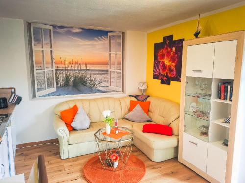 a living room with a couch and two windows at Kleine Mariken in Zingst