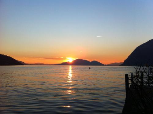 a sunset on a lake with mountains in the background at Hotel Bellavista Meublè in Monte Isola