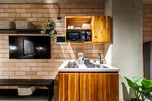 a kitchen with a sink and a microwave at Otalu Suites in Medellín
