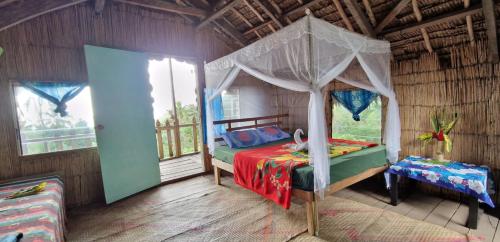 a bedroom with a bed with a canopy at Lava view Bungalows in Isaka