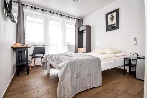 a bedroom with a bed and a desk and a window at Willa Góry A - Noclegi z widokiem na góry śniadaniami i sauna in Bukowina Tatrzańska