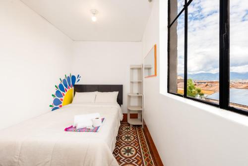 アヤクーチョにあるRetablo Boutique Hotelのベッドが2つと大きな窓がある寝室