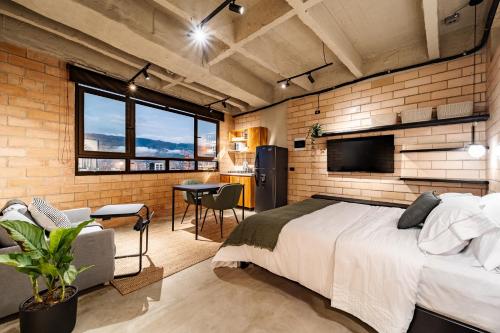 a bedroom with a large bed and a kitchen at Otalu Suites in Medellín