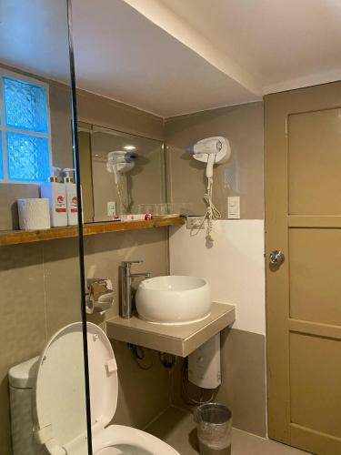a bathroom with a toilet and a sink at IL Mare Sakura Resort Boracay in Boracay