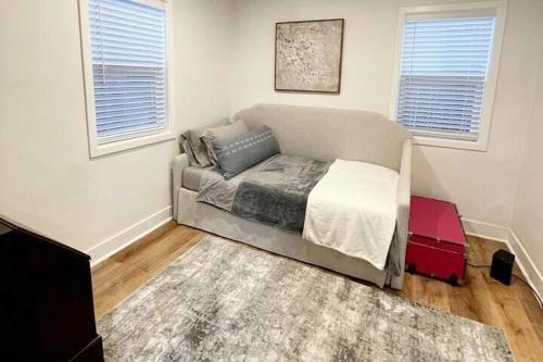 a bedroom with a bed in a room with windows at Charming 2 bedroom house 1 mile from U of O in Eugene