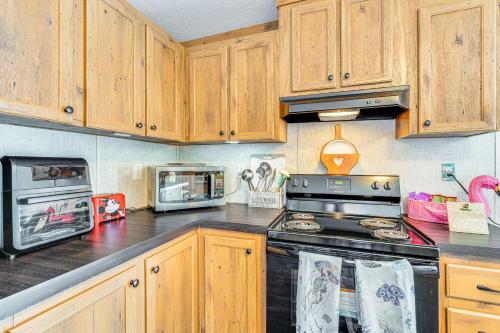 a kitchen with wooden cabinets and a stove top oven at Pet-Friendly Punta Gorda Getaway with Fire Pit! in Punta Gorda