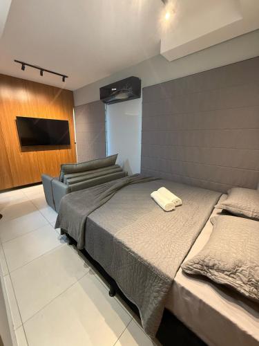 a bedroom with two beds and a television in it at Apartamento 75 - Aconchegante in Ribeirão Preto