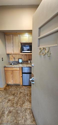 a kitchen with wooden cabinets and a refrigerator at Willard Munger Inn in Duluth