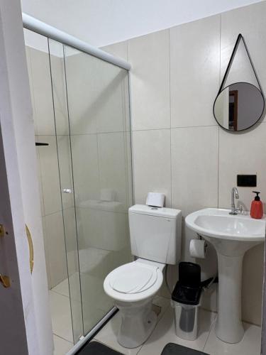 a white bathroom with a toilet and a sink at CASA DE TUCA in Ilhabela