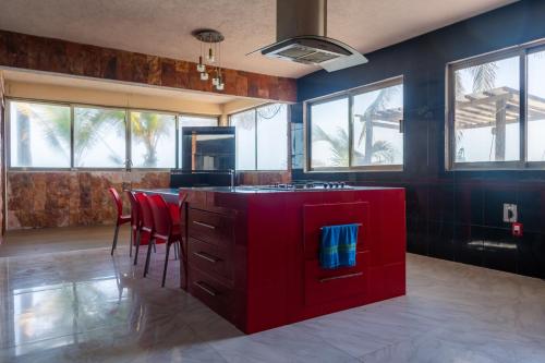 a kitchen with a red island and red chairs at Casa de playa Pams in Cedro