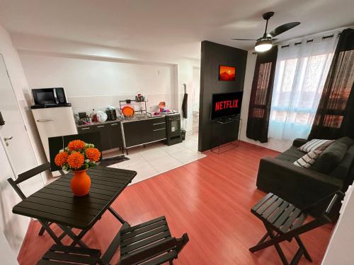 een woonkamer met een vaas met bloemen op een tafel bij Prático Viena - Free Parking - 24 hour doorman in Parque Industrial