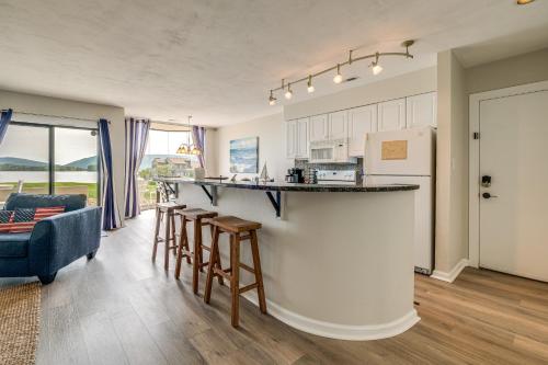 a kitchen and living room with a counter and chairs at Resort Condo on Smith Mtn Lake Linens Included! in Moneta