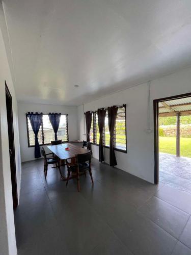 a dining room with a table and some windows at Stephanie's Homestay in Matei