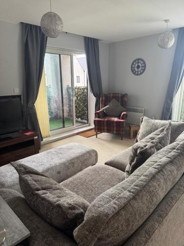 a living room with a couch and a tv at Beautiful 2 bedroom apartment in lawley village in Lawley Bank