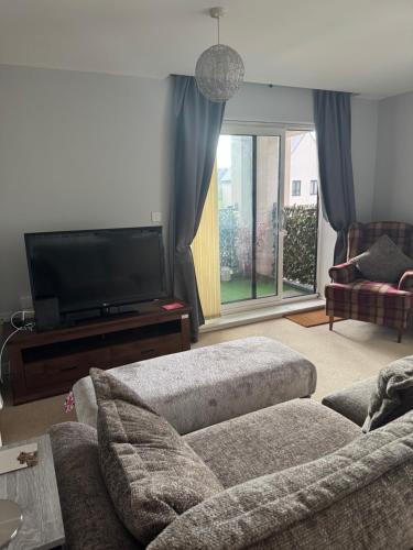 a living room with a couch and a flat screen tv at Beautiful 2 bedroom apartment in lawley village in Lawley Bank