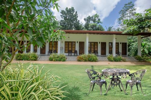 a table and chairs in front of a building at The Regency Villa by Escape Essence in Unawatuna