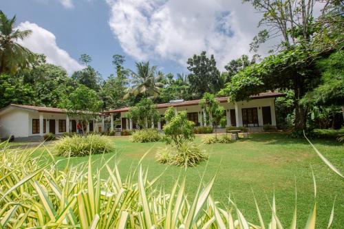 an exterior view of a house with a yard at The Regency Villa by Escape Essence in Unawatuna
